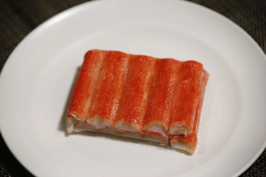A bundle of red-and-white kanikama seafood sticks on a white plate