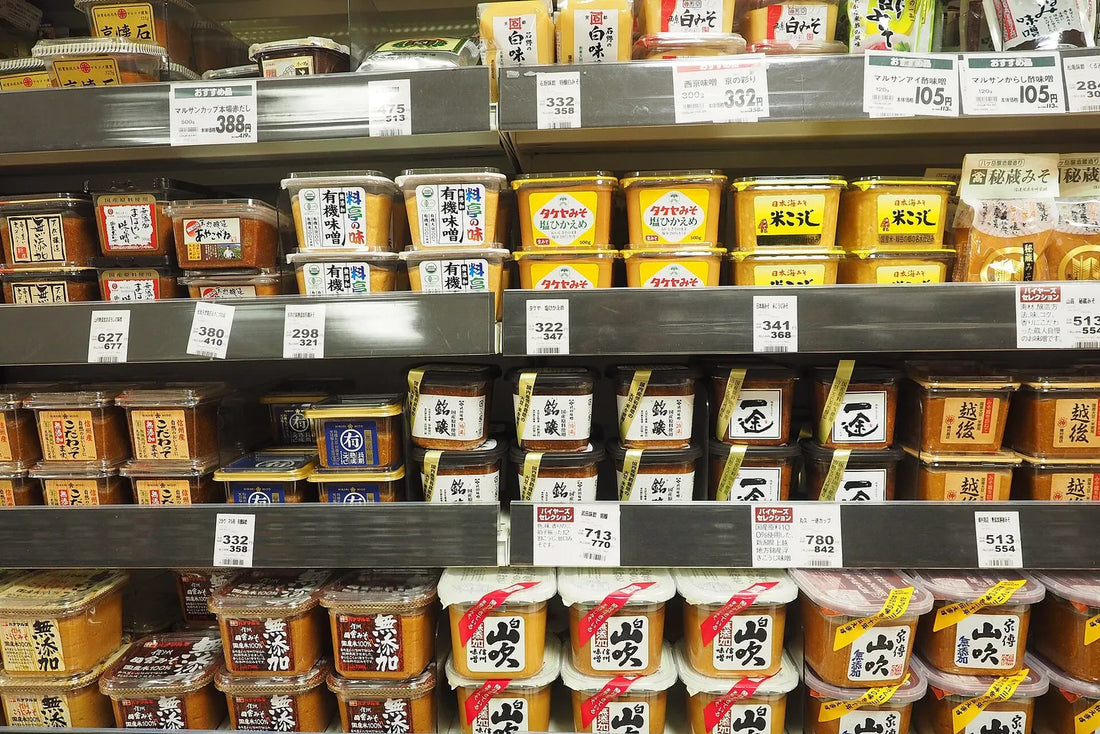 Shelves stacked with tubs of Japanese miso paste, each labelled in Japanese