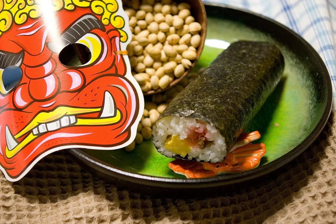 Roasted soybeans, a whole uncut sushi roll and a red paper ogre mask on a table, ready for Setsubun