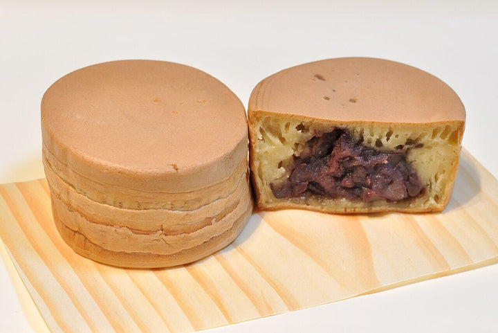Imagawayaki - a thick round Japanese cake off a hotplate, crisp at the rim, red bean sealed inside