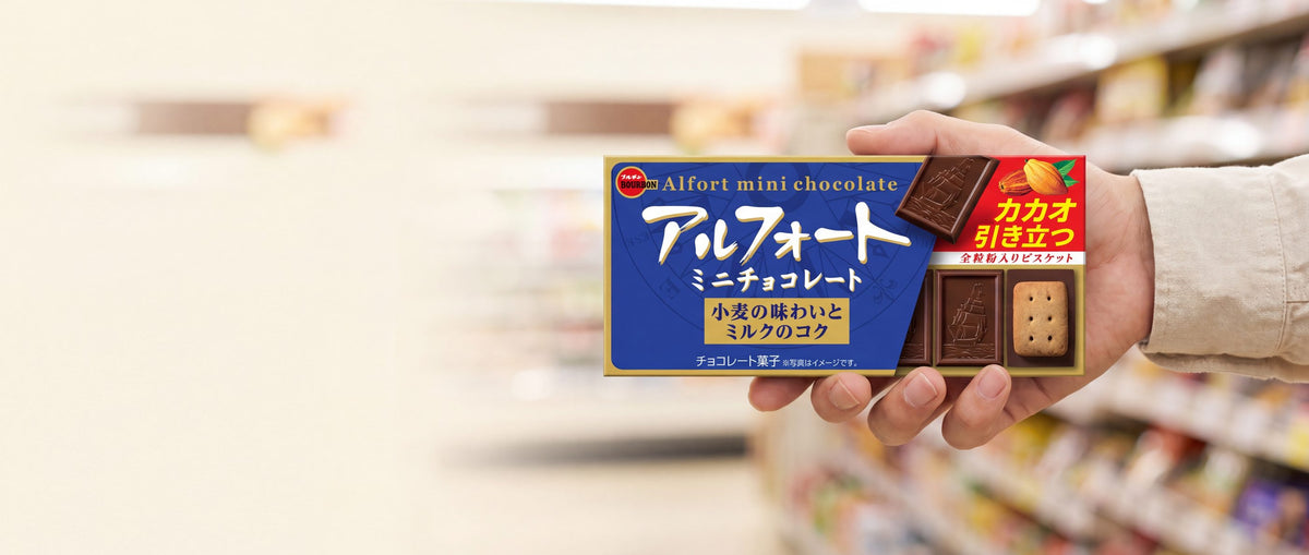 A hand holding a box of Bourbon Alfort Mini Chocolate, a Japanese chocolate biscuit snack, in a supermarket aisle